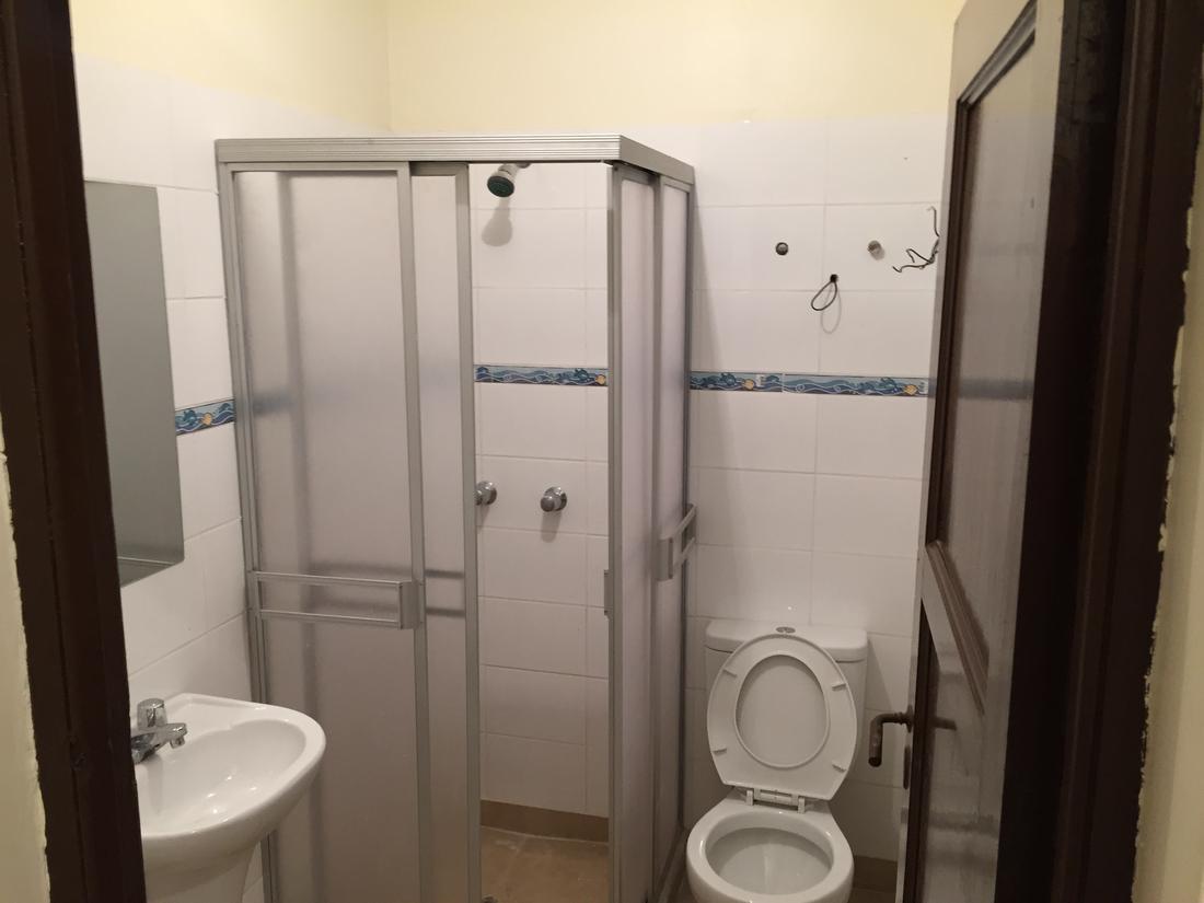 After: a new bathroom with a shower cubicle, sink and toilet