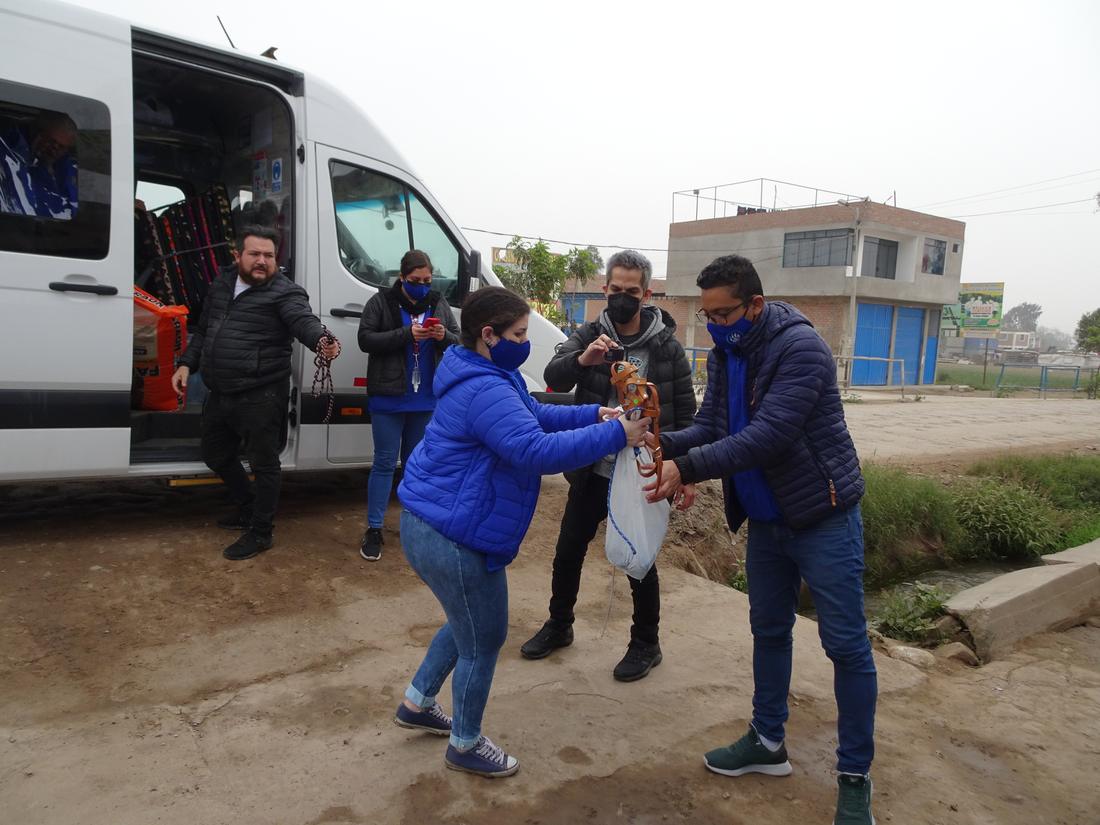 Volunteers in blue unloading muzzles and leads from a white van